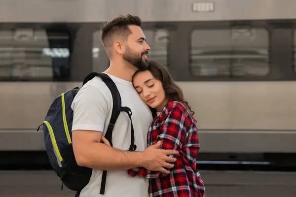 Long-distance relationship. Beautiful couple hugging on platform of railway station