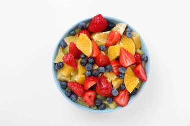 Beyaz arka planda kasede lezzetli meyve salatası, üst manzara.