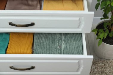 Sıralama ve düzenleme. İçinde farklı katlanmış kıyafetler olan çekmeceler.