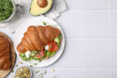 Lezzetli kruvasan ve ürünlerle bembeyaz masada bezenmiş düz bir kompozisyon. Metin için boşluk