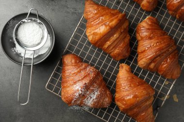 Gri masadaki pudra şekerli enfes taze kruvasanlar.
