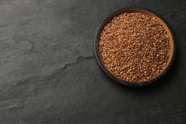 Kuru karabuğdaylı kase, siyah masa, üst manzara. Metin için boşluk