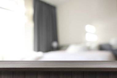Yatak odasında boş ahşap masa, içi bulanık. Tasarım için boşluk