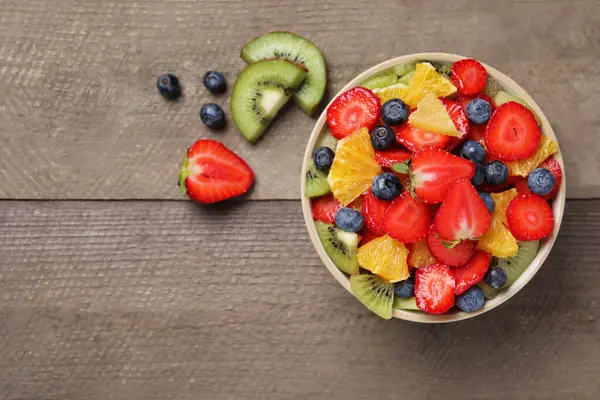 Delicious Fresh Fruit Salad Bowl Ingredients Wooden Table Flat Lay — Stock Photo, Image