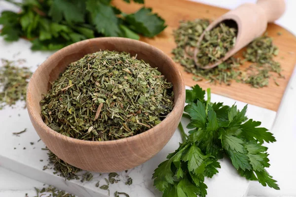 Dried parsley and fresh leaves on table, closeup