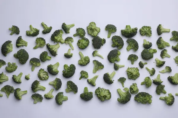 Beyaz Zemin Üzerinde Birçok Taze Yeşil Brokoli Parçaları Düz Yatıyordu — Stok fotoğraf
