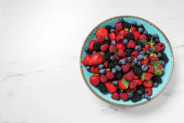ホワイトテーブル トップビューのボウルに多くの異なる新鮮な熟した果実 テキスト用スペース — ストック写真