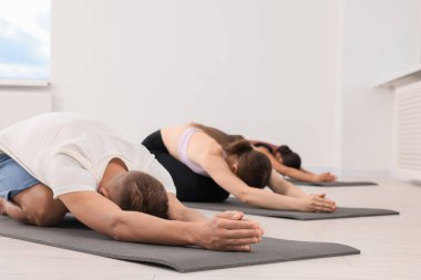 Paspaslar üzerinde yoga yapan bir grup insan, mesaj için yer var.