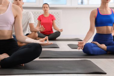 Paspaslar üzerinde yoga yapan bir grup insan, yakın plan.