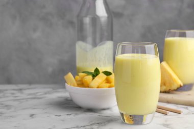 Lezzetli ananas püresi ve beyaz mermer masada dilimlenmiş meyve, metin için yer var.