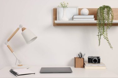 Merkez ofis. Laptop, klasik kamera, lamba ve kırtasiye malzemeleri beyaz masa içinde.