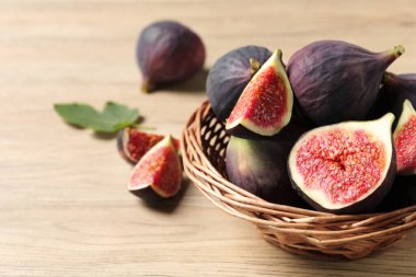 Ahşap masada bütün ve olgun incirleri kes, yakın plan. Metin için boşluk