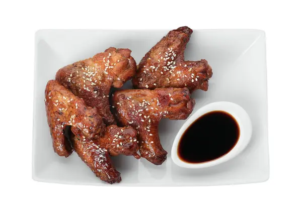 Glazed chicken wings and soy sauce isolated on white, top view