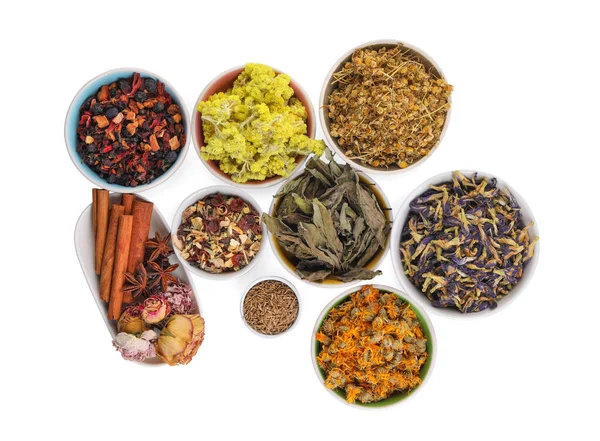 Many different dry herbs, flowers and spices in bowls isolated on white, top view