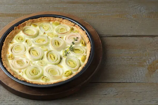 Tasty leek pie on wooden table. Space for text