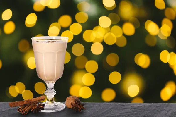 Masadaki cam bardakta nefis eggnog bulanık Noel ışıklarına karşı, mesaj için yer