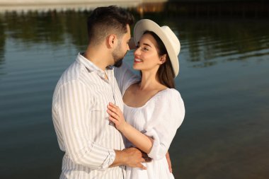 Romantik bir randevu. Güzel bir çift göl kenarında vakit geçiriyor.