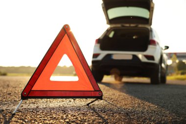 Uyarı üçgeni ve yol kenarındaki kırık araba, seçici odak