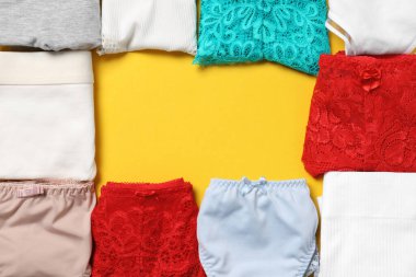 Sarı arka planda katlanmış şık kadın iç çamaşırından yapılmış bir çerçeve. Metin için boşluk