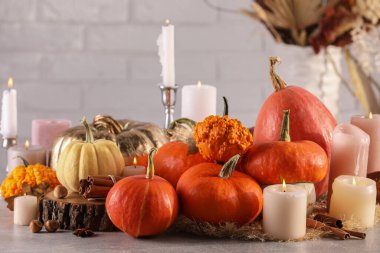 Masada yanan mumlar ve balkabaklarıyla güzel bir kompozisyon.