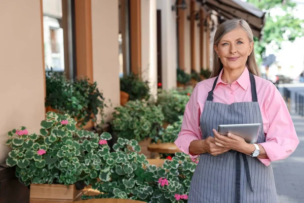 stock image Happy business owner with tablet near her cafe outdoors, space for text