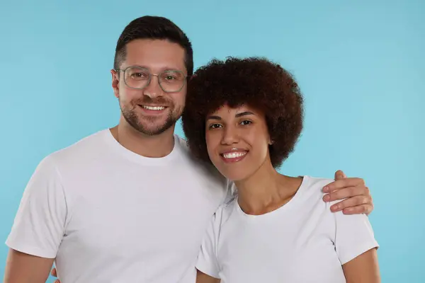 International dating. Portrait of happy couple on light blue background