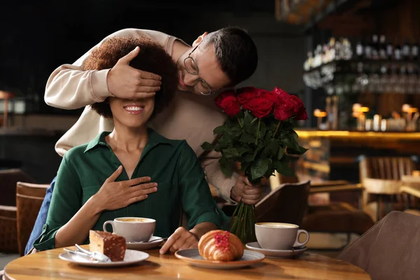 Mezinárodní Randění Pohledný Muž Představuje Růže Své Přítelkyni Restauraci — Stock fotografie