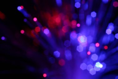 Optik fiber iplikler siyah arkaplan üzerinde farklı renk ışıkları iletiyor, makro görünüm