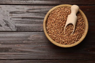 Tahta masadaki kuru karabuğdaylı kase ve kepçe, üst manzara. Metin için boşluk