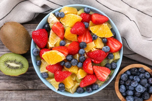 Delicious Fresh Fruit Salad Ingredients Bowl Wooden Table Flat Lay — Stock Photo, Image