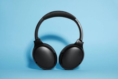 Açık mavi arka planda modern kablosuz kulaklıklar