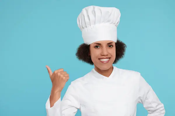 Glad Kvinnlig Kock Uniform Pekar Något Ljusblå Bakgrund — Stockfoto