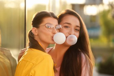 Dışarıda baloncuklu diş etleri çıkaran güzel genç kadınlar.