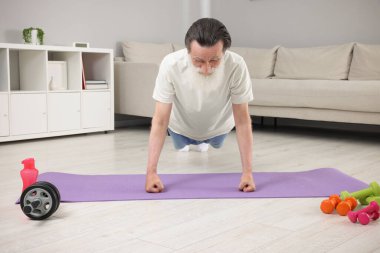 Spor giyim bölümündeki son sınıf öğrencisi evde spor paspası üzerinde alıştırma yapıyor.