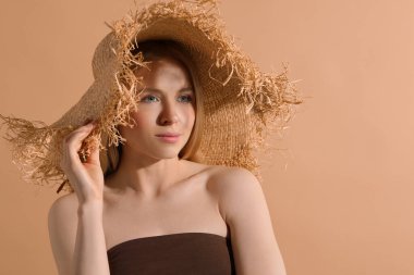Bej arka planda hasır şapkalı güzel genç kadın, metin için yer