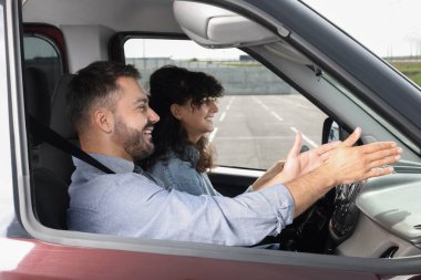 Ehliyet kursu. Otoparkta sürüş eğitmeniyle ders sırasında mutlu öğrenci.