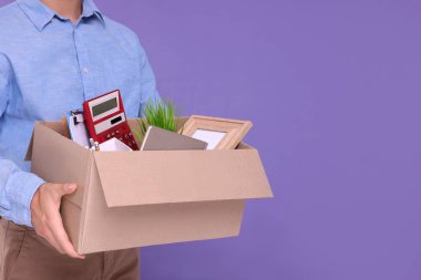 Mor arka planda kişisel ofis eşyaları olan işsiz bir adam, yakın plan. Metin için boşluk