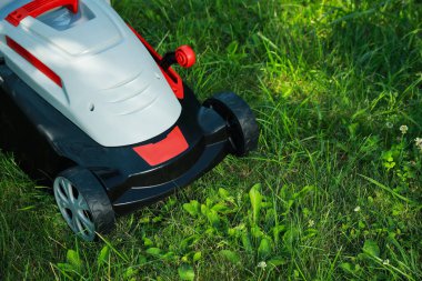 Bahçede çim biçme makinesiyle yeşil çimenleri biçmek, metin için boşluk