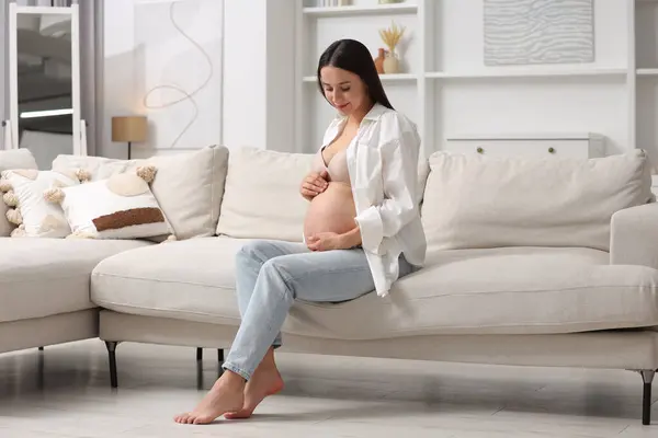 Όμορφη Έγκυος Γυναίκα Που Κάθεται Στον Καναπέ Στο Σπίτι — Φωτογραφία Αρχείου