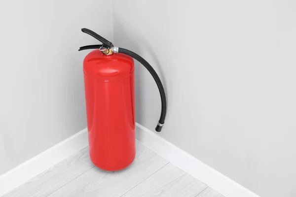 stock image Fire extinguisher on floor indoors, space for text