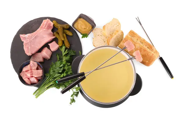 stock image Oil in fondue pot, forks, sauce, pieces of raw meat and other products isolated on white, top view