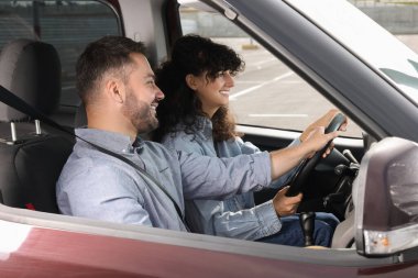 Ehliyet kursu. Otoparkta sürüş eğitmeniyle ders sırasında mutlu öğrenci.