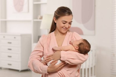 Anne yeni doğmuş bebeğini kucağında tutuyor.