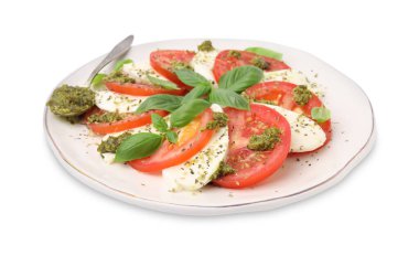 Bir tabak lezzetli Caprese salatası ve beyaz soslu kaşık.