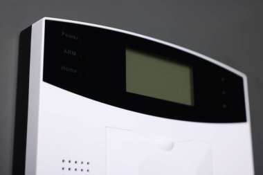 Gri duvardaki ev güvenlik alarmı sistemi, yakın plan.