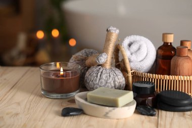 Spa ürünleri ve banyodaki ahşap masada mum yakma kompozisyonu, yakın çekim. Metin için boşluk