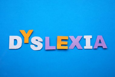 Kelime disleksisi mavi arkaplanda kağıt harflerden oluşur, düz yatar