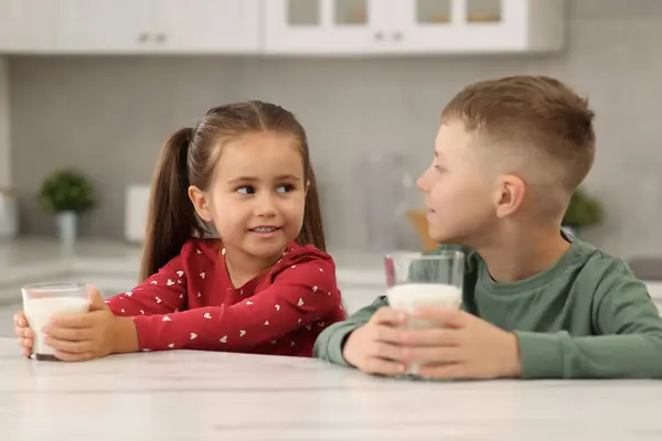 キッチンのホワイトテーブルでミルクのメガネとかわいい子供たち — ストック写真
