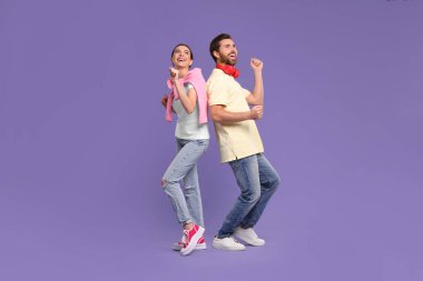 Mutlu çift menekşe arka planda dans ediyor.