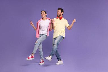 Mutlu çift menekşe arka planda dans ediyor.